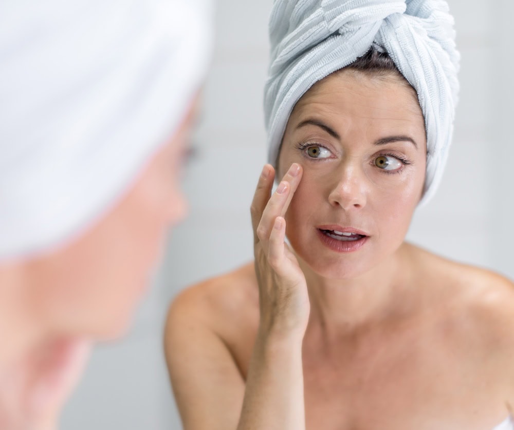 Femme appliquant un soin facial pour lutter contre le relâchement cutané.