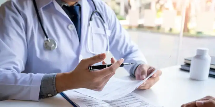 Médecin en consultation pour une liposuccion, discutant des options avec un patient.