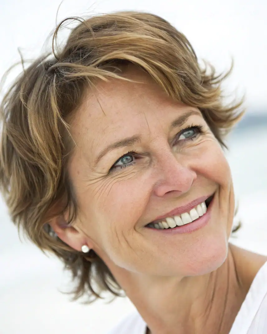 Femme souriante avec peau lisse et rajeunie, illustration des traitements esthétiques pour rajeunir.