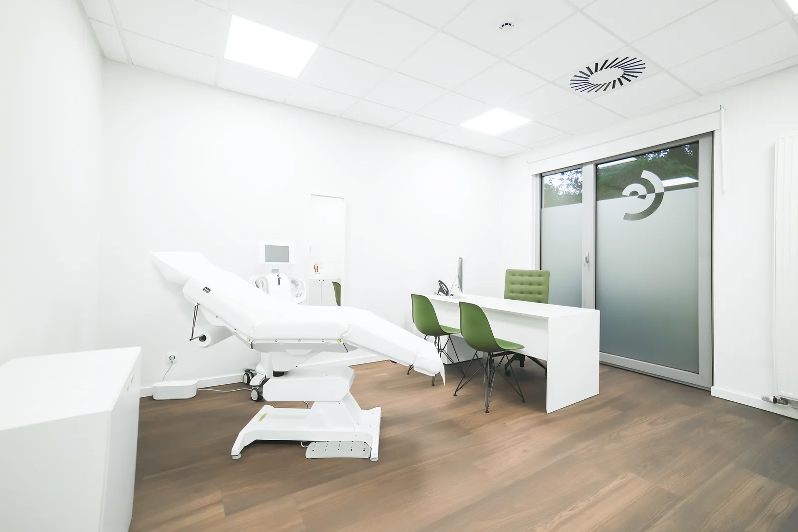 Cabinet de consultation de Claris Liège, fauteuil de traitement, bureau blanc et chaises vertes