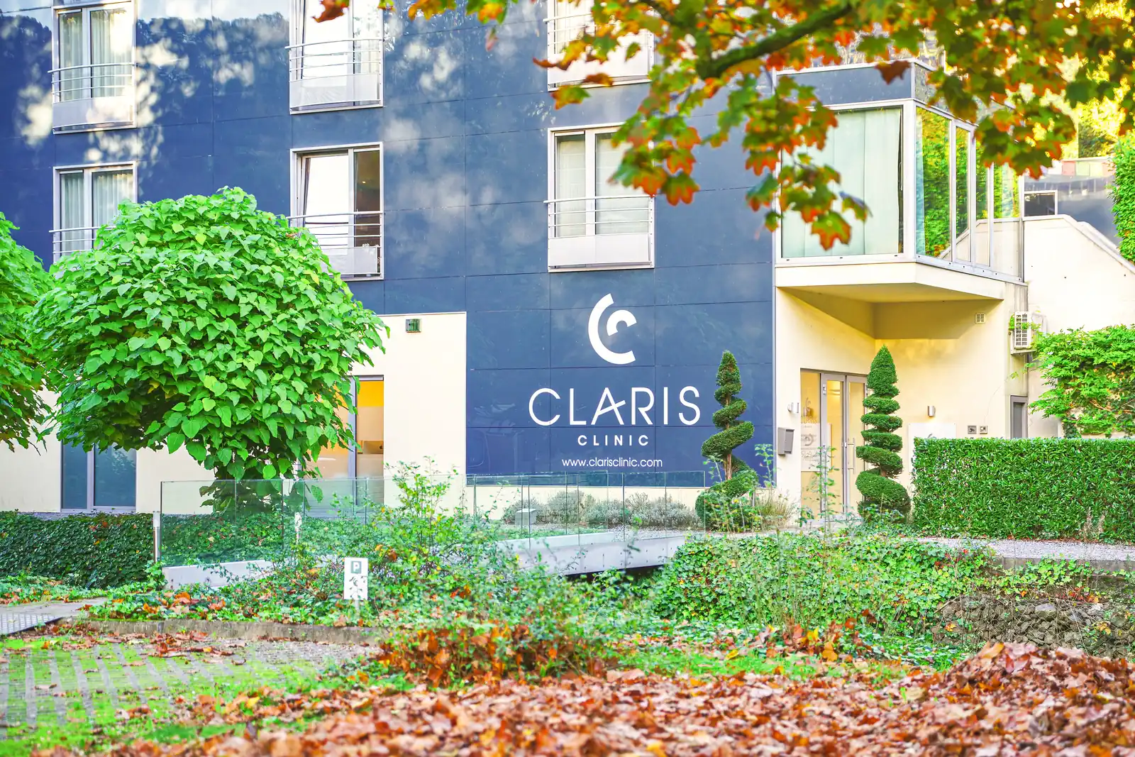 Façade de Claris Liège au Château des Thermes de Chaudfontaine, logo Claris Clinic et jardin